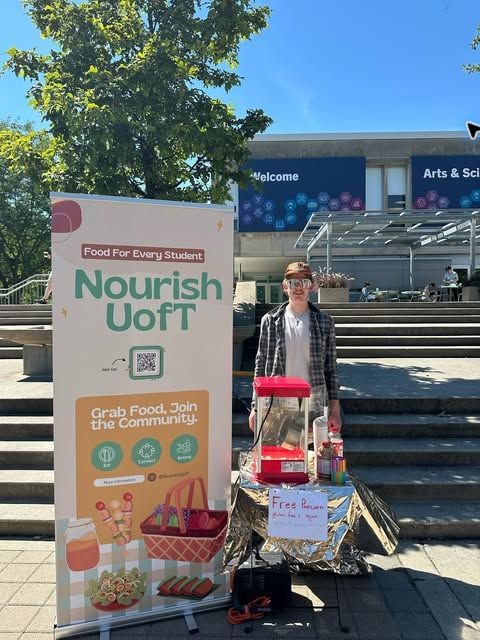 Nourish UofT student pop-up with a campus food access banner and free popcorn